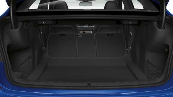 BMW 3-serie Sedan, genomlastningssystem. Närbild på det öppna bagageutrymmet med baksätets ryggstöd nedfällda till hälften.