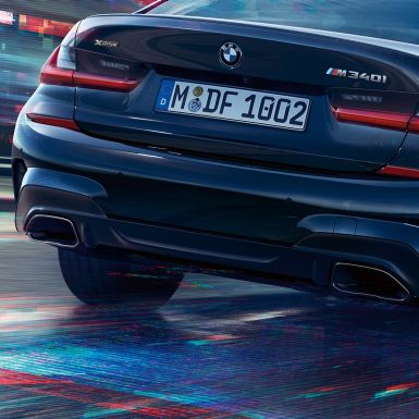 BMW 3-serie Sedan, M ändrör. Närbild på bakpartiet hos BMW 3-serie Sedan med M-specifika ändrör i Ceriumgrå metallic.