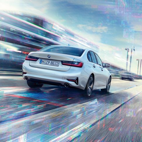 BMW 330e Sedan, sedd bakifrån. BMW 330e Sedan i rörelse sedd snett bakifrån.