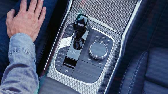 BMW 3-serie Sedan (G20), Steptronic sportväxellåda. Detaljbild ur fågelperspektiv av mittkonsolen i BMW 3-serie Sedan (G20) med växelspaksknopp och Steptronic-sportväxellåda.
