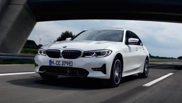 Laddhybrid BMW 3-serie Sedan 2021 G20 sedd snett framifrån körande Laddhybrid BMW 3-serie Sedan 2021 G20 sedd snett framifrån körande på väg