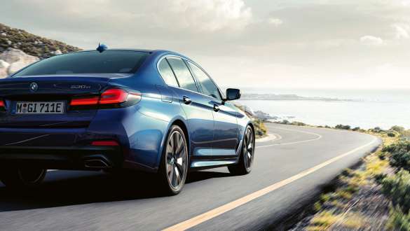 BMW 5-serie Sedan med aktiv integralstyrning G30 Aktiv integralstyrning BMW 5-serie Sedan G30 Facelift 2020 trefjärdedelsvy bakifrån körandes