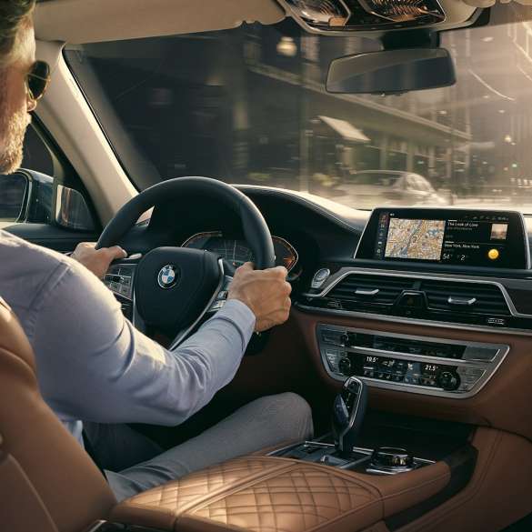 BMW 7-serie sedan Connectivity Features BMW 7-serie sedan: En man sitter i BMW och använder Connectivity Features