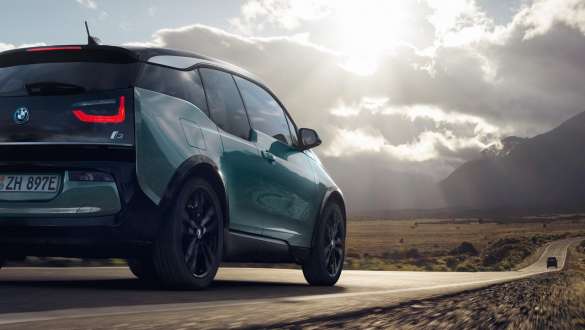 BMW i3 2018 sedd snett bakifrån körandes på landsväg BMW i3 I01 2018 Jucarobeige med accent Frozen Grey metallic sedd snett bakifrån körandes på landsväg