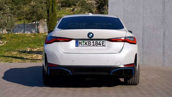 BMW i4 eDrive40 G26 2021 sedd bakifrån parkerad BMW i4 eDrive40 G26 2021 Mineralvit sedd bakifrån parkerad