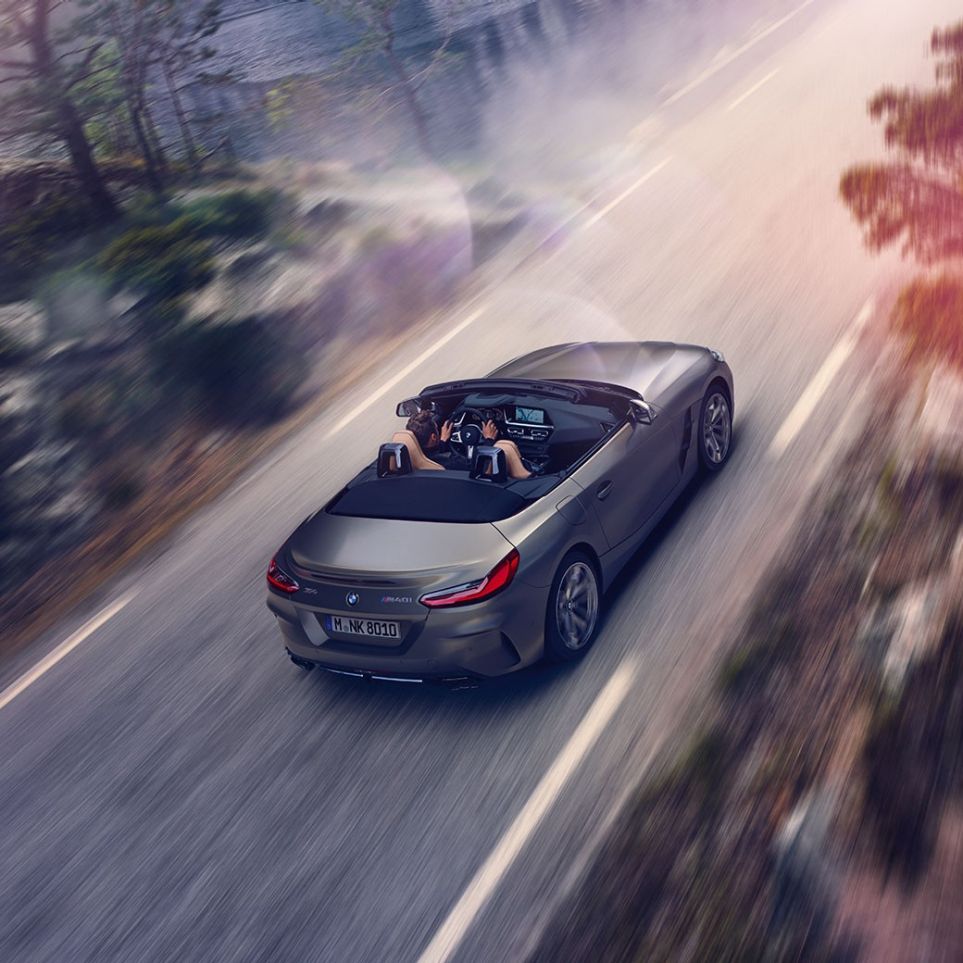 BMW Z4 M40i G29 Cariolet med öppen sufflett BMW Z4 M40i Roadster G29 2019 Cabriolet BMW Individual Frozen Grey metallic körandes med öppen sufflett sedd ur fågelperspektiv