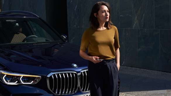 Kvinna framför BMW BMW Mobile Care kvinna framför en BMW