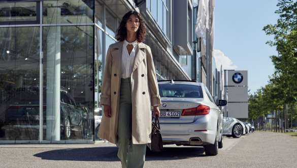 Kvinna framför BMW återförsäljaranläggning BMW Service Inclusive kvinna framför BMW återförsäljaranläggning