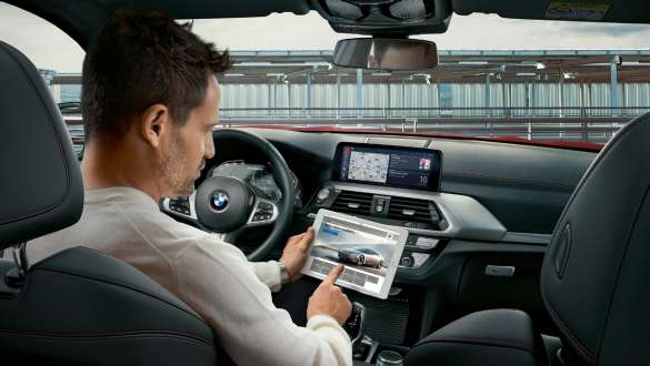 BMW Connected. BMW X4 M, BMW Connected, kvinna med upplyst klot i handen.