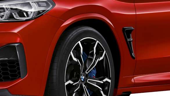 BMW M4 Competition, närbild bakifrån från sidan. BMW X4 M Competition i Torontoröd metallic, Exteriör, M Carbon Exteriör, närbild bakifrån från sidan, M-specifikt chassi.