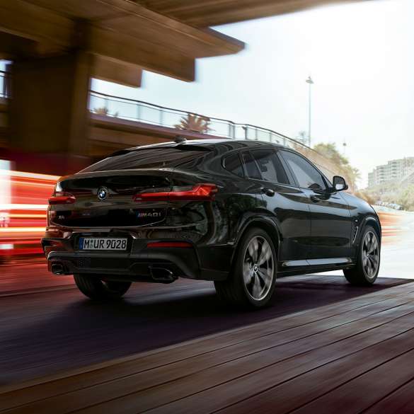 BMW X4 M40i, Trefjärdedels vy framifrån. BMW X4 M40i i Safirsvart metallic, kommer körande, Exteriör, trefjärdedels vy framifrån med ljusstrimmor.