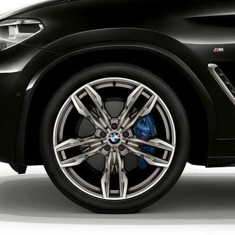 BMW X4 M40i och BMW X4 M40d, 21-tums M lättmetallfälgar. BMW X4 M40i och BMW X4 M40d i Safirsvart metallic, Exteriör, vy från sidan med 21-tums M lättmetallfälgar i dubbeleker-design.