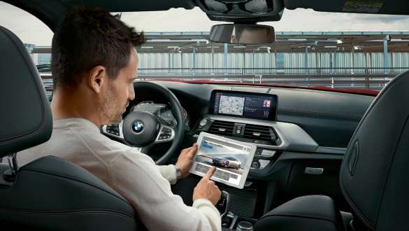 WLAN Hotspot BMW X4 WLAN Hotspot BMW X4 G02 2018 man som använder surfplattan i sin BMW
