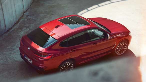 BMW X4 sedd ur fågelperspektiv. BMW X4 M40i G02 2018 Flamencoröd briljanteffekt röd sedd ur fågelperspektiv