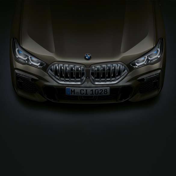 BMW X6 front. Närbild på BMW X6 front med BMW-njure i Iconic Glow sedd ur ett fågelperspektiv.