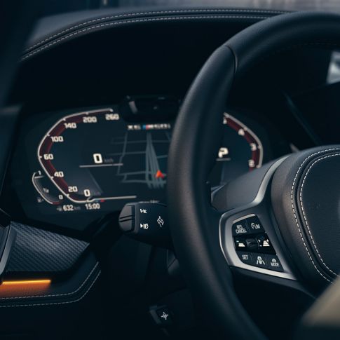 BMW-assistanssystem. Närbild på BMW-interiör med fokus på kombiinstrument.