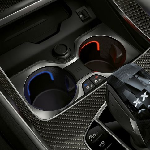 Uppvärmd mugghållare. Närbild på BMW-interiör med fokus på uppvärmd mugghållare.