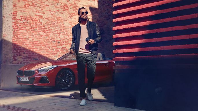 BMW Z4 Roadster på sidogata Man på en sidogata framför BMW Z4 Roadster