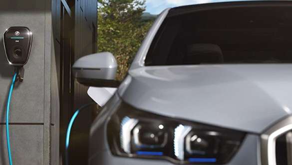 BMW Service Inclusive för nya bilar BMW Service Inclusive en kvinna går framför en BMW i4 längs kusten