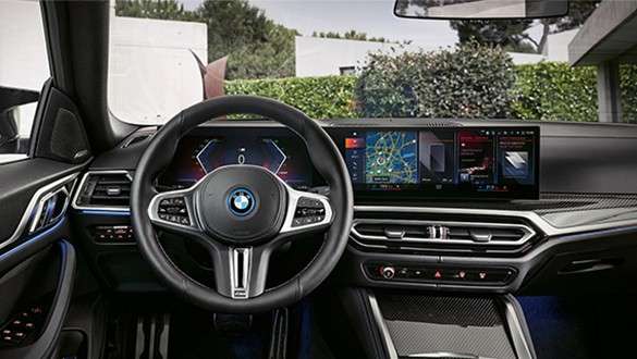 BMW Service Inclusive för elbilar BMW Service Inclusive en kvinna står framför en BMW i4 vid en laddstolpe