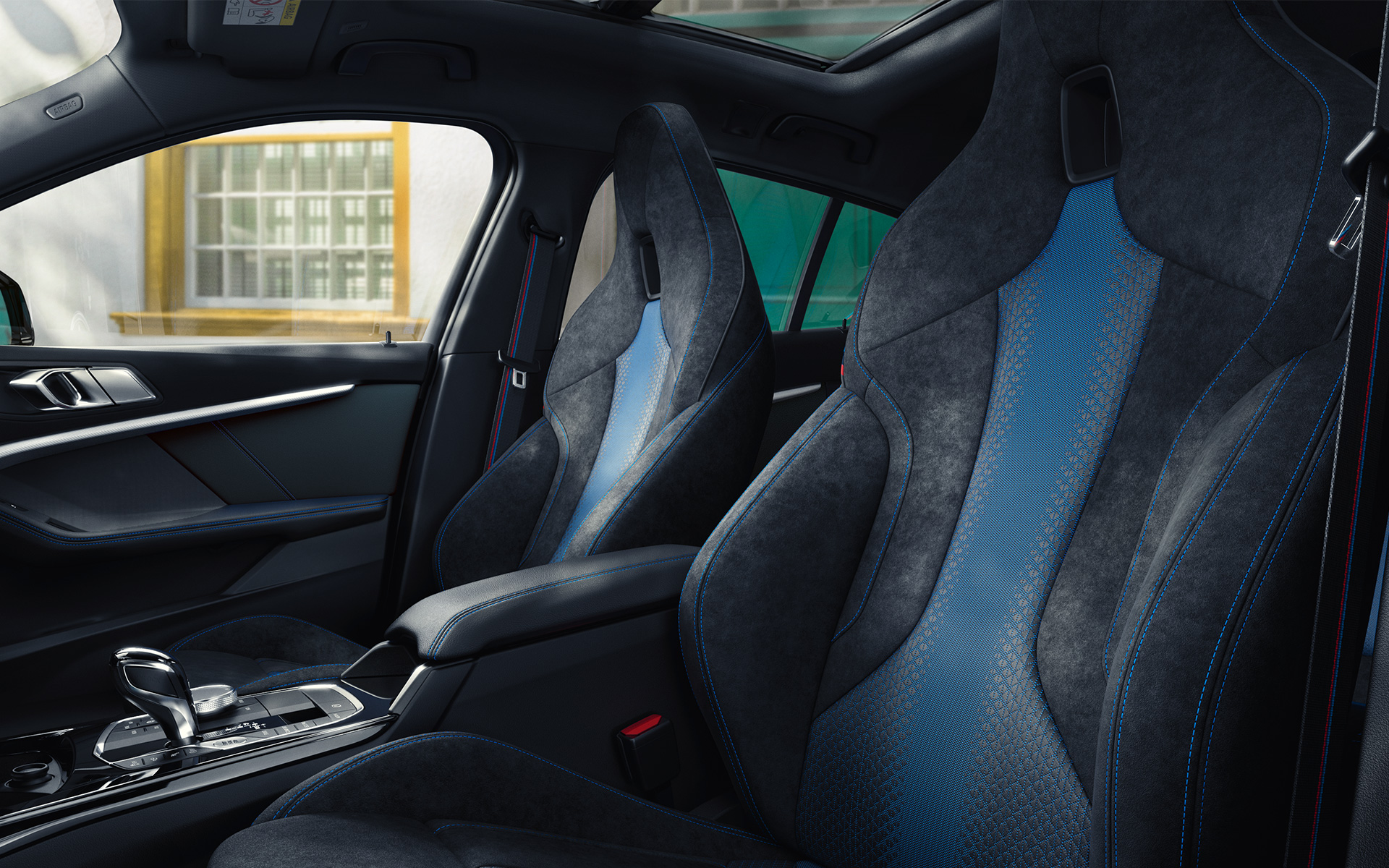 BMW 1-serie F40 M sportstolar Ergonomiskt formgivna M sportstolar i BMW 1-serien F40 med blå kontrastsömmar och integrerade nackstöd