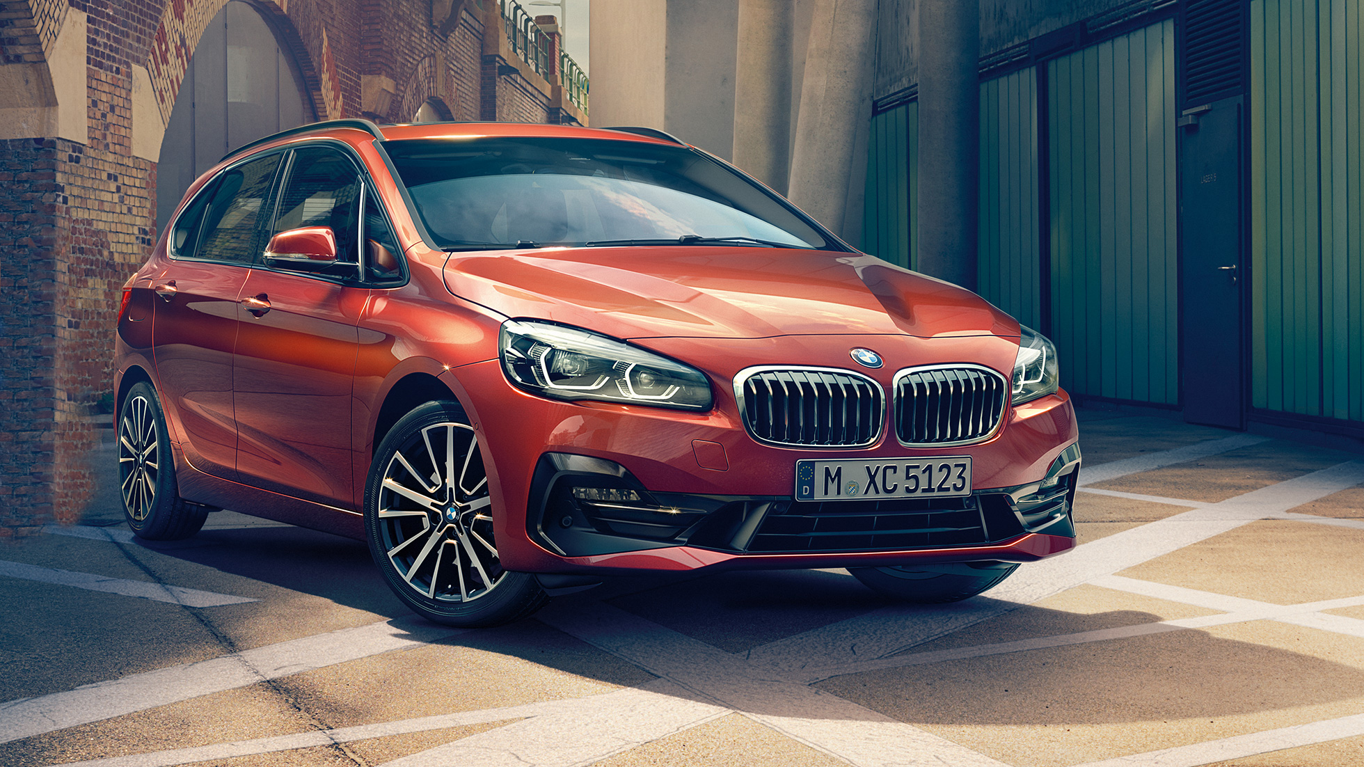 Exteriör BMW 2-serie Active Tourer BMW 2-serie Active Tourer F45 Facelift 2018 Sunset Orange metallic sedd snett framifrån parkerandes i gränd