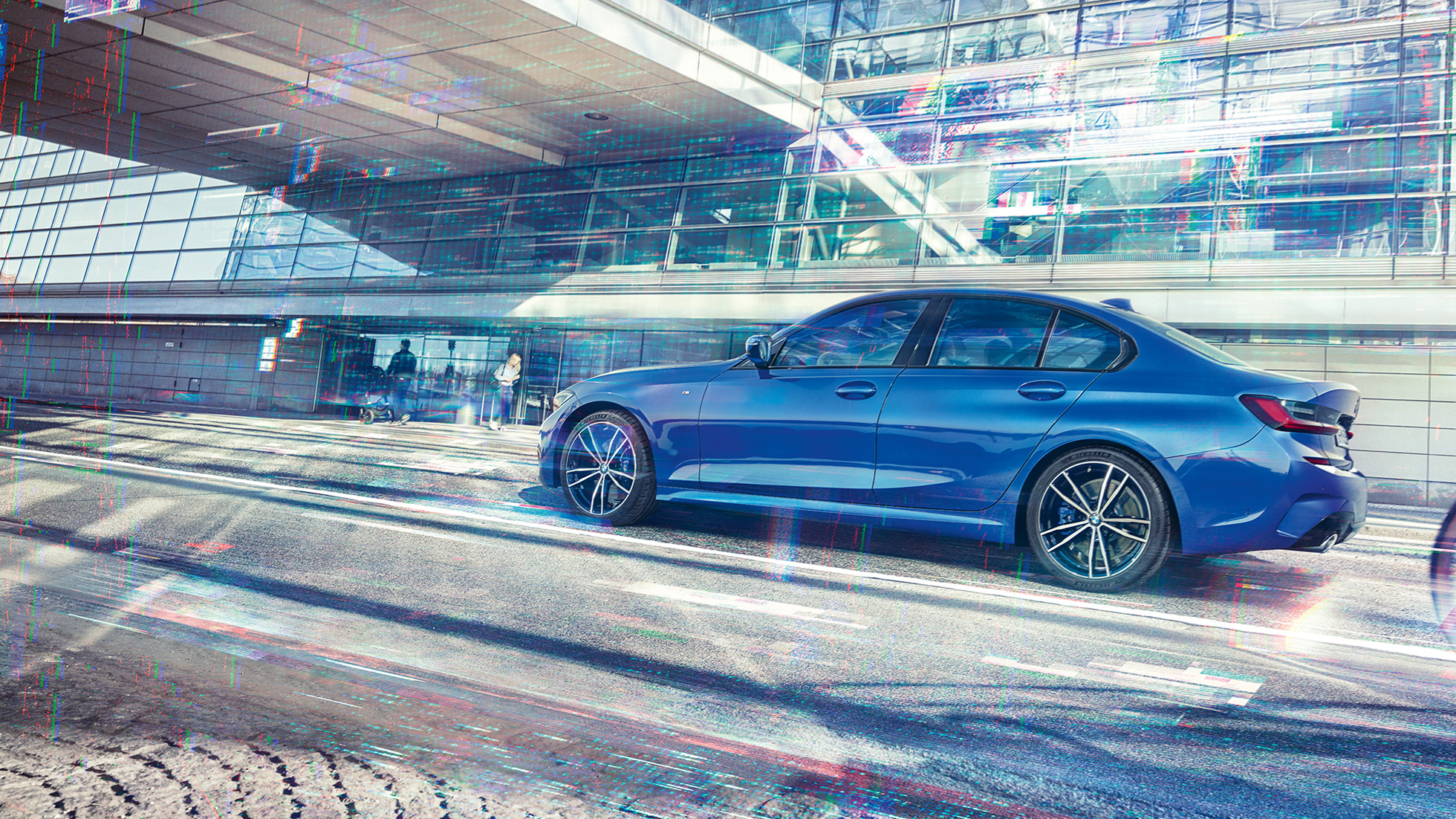 BMW 3-serie Sedan från sidan. BMW 3-serie Sedan från sidan i dagsljus stående framför en glasfasad.