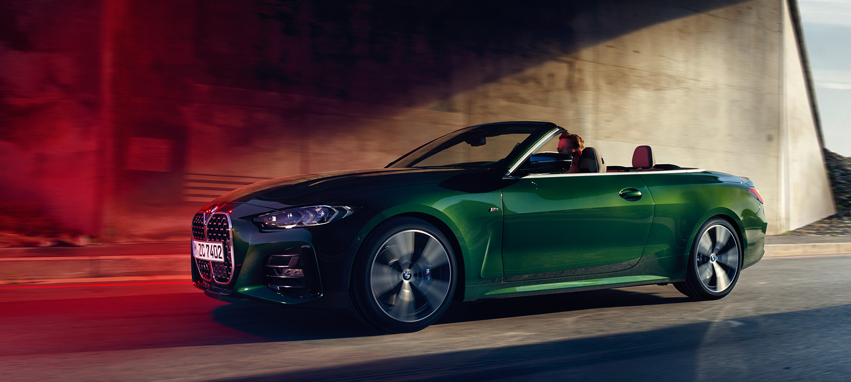 BMW 4-serie Cabriolet G23 2020 sedd snett från sidan körandes BMW 4-serie Cabriolet G23 2020 Sanremo Green metallic sedd snett från sidan körandes