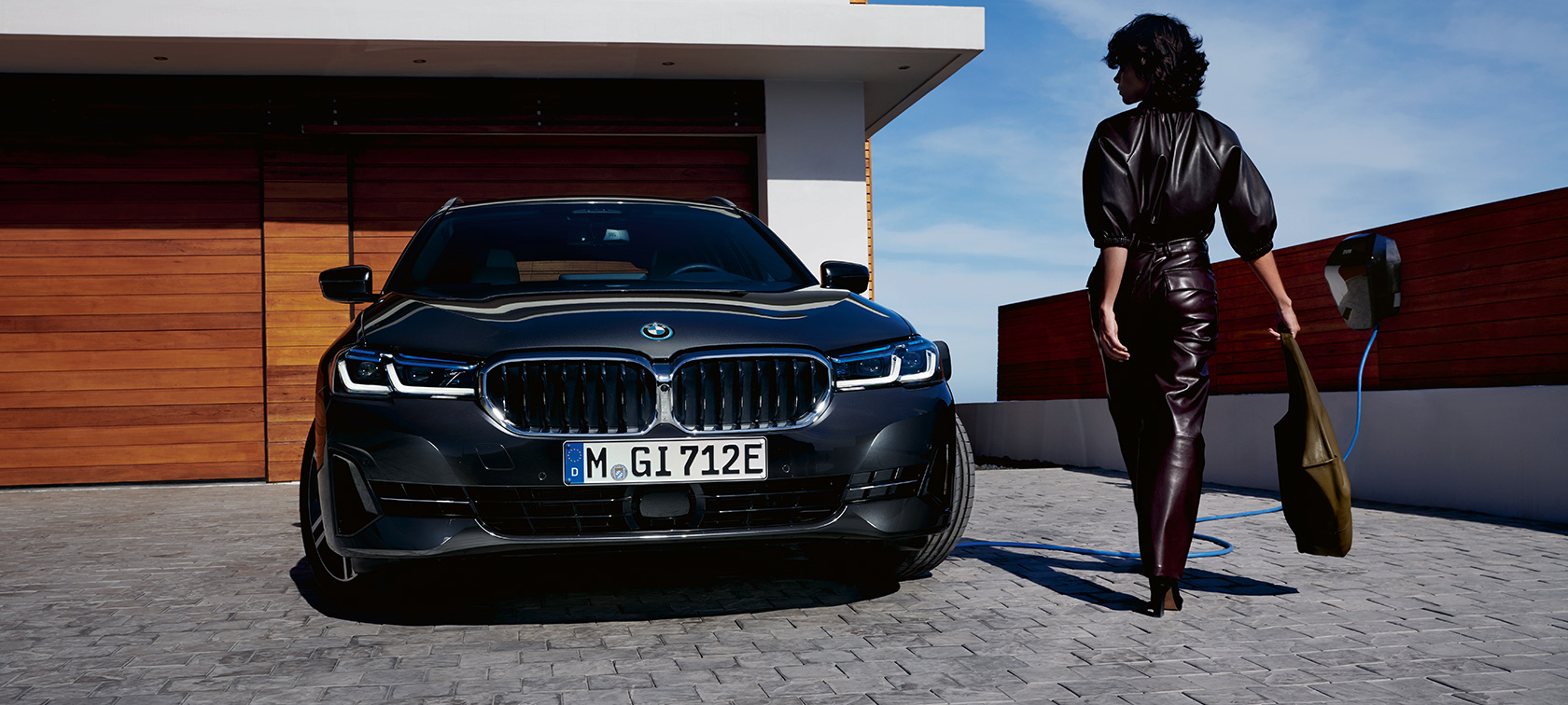 Laddhybrid BMW 5-serie Touring 2021 G31 LCI sedd framifrån laddande Laddhybrid BMW 5-serie Touring 2021 G31 LCI sedd framifrån laddande med modell