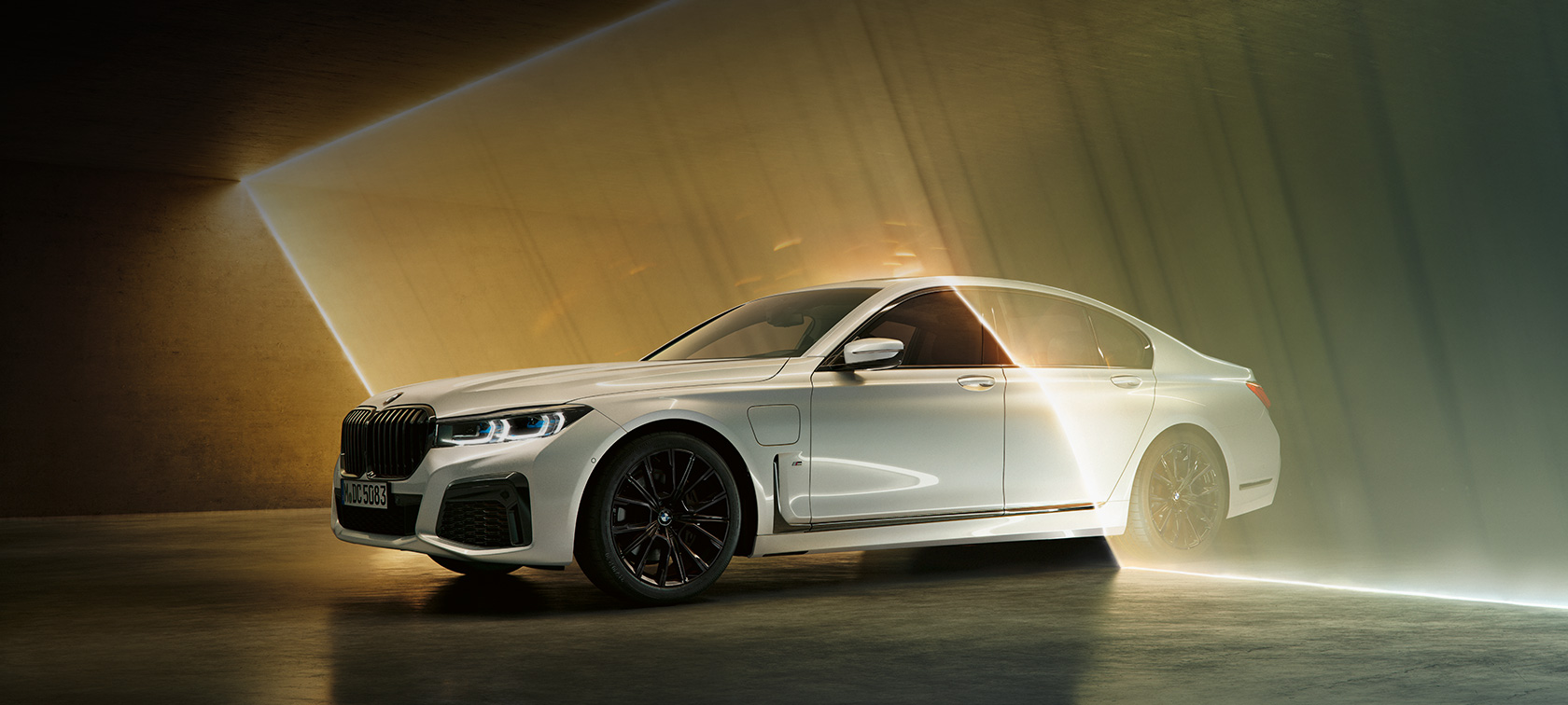 BMW 7-serie sedan, vit, i trefjärdedels vy framifrån BMW 7-serie sedan: Vit BMW i trefjärdedels vy framifrån omgiven av ljusstrålar