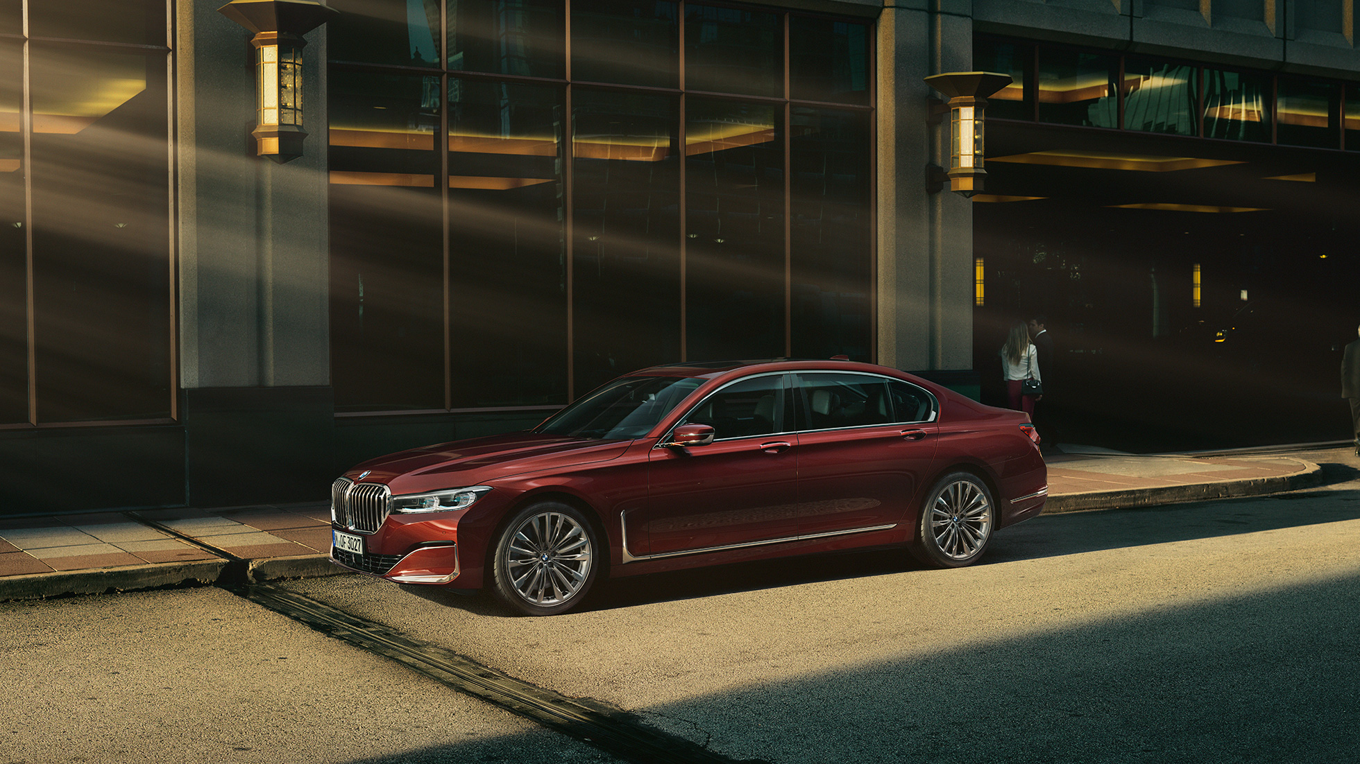 BMW Individual 7-serie sedan, sedd från sidan BMW Individual 7-serie sedan i rött i stadsmiljö, sedd från sidan