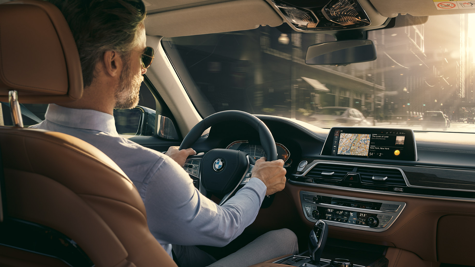 BMW 7-serie sedan Connectivity Features BMW 7-serie sedan: En man sitter i BMW och använder Connectivity Features