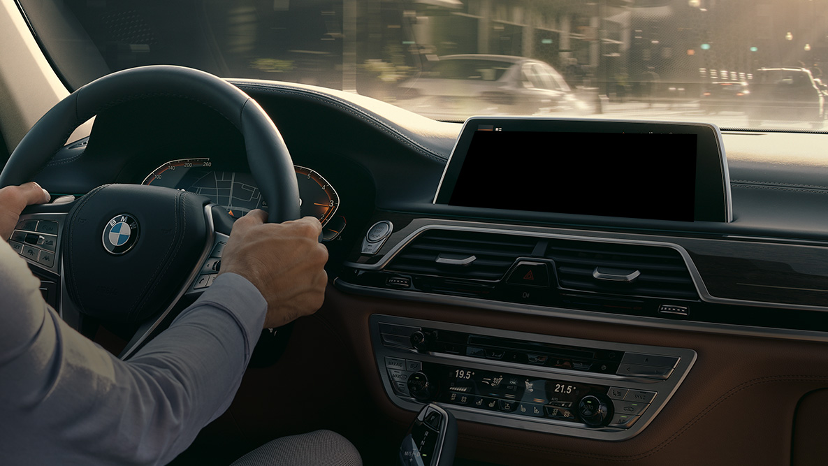 BMW Intelligent Personal Assistant BMW Intelligent Personal Assistant: En man kör i BMW, närbild av Live Cockpit Professional