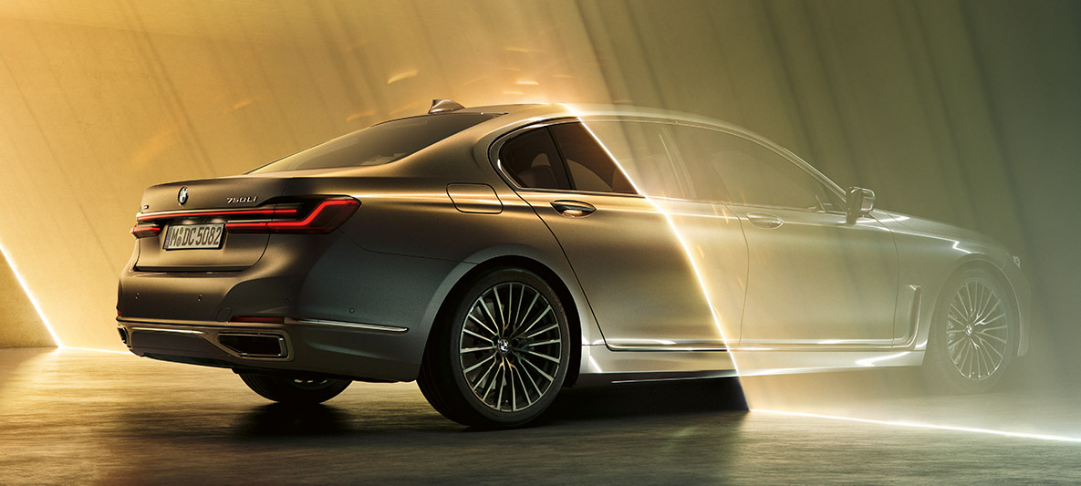 BMW 7 Series Sedan in Bernina Grey BMW 7 Series Sedan in Bernina Grey in three-quarter rear view surrounded by beam of light
