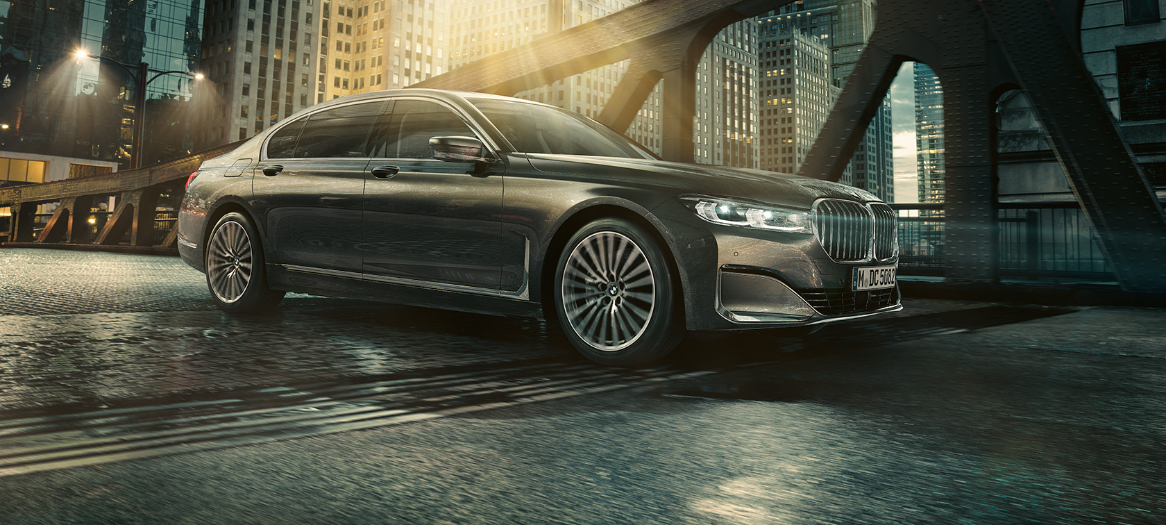 BMW 7-serie Sedan, sedd från sidan BMW 7-serie Sedan är parkerad framför ett upplyst hotell med öppen dörr, sedd från sidan