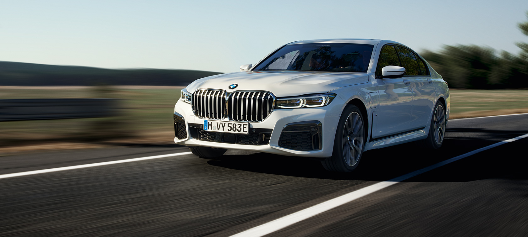 BMW 7-serie Sedan laddhybrid G11 G12 sedd snett framifrån körandes En BMW 7-serie Sedan laddhybrid G11 G12 sedd snett framifrån kör på vägen