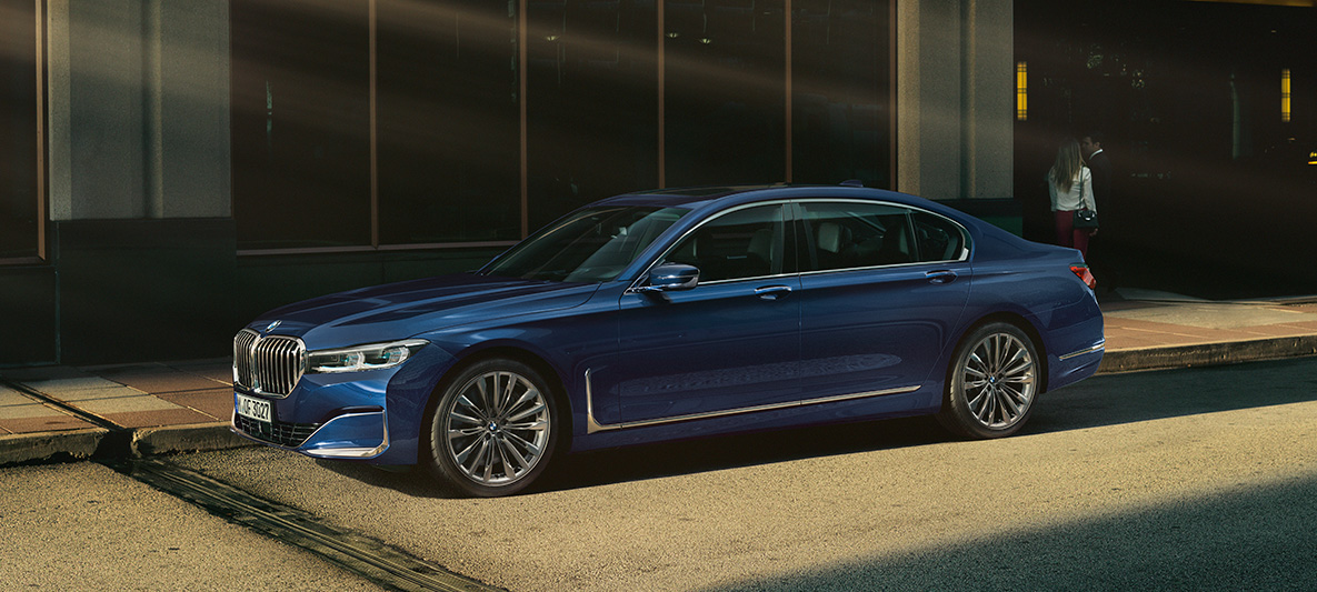 BMW Individual 7-serie Sedan, sedd från sidan BMW Individual 7-serie Sedan i rött i stadsmiljö, sedd från sidan