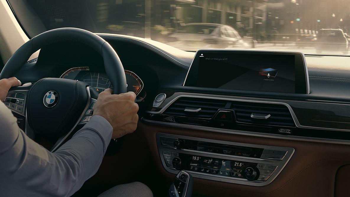 BMW Intelligent Personal Assistant BMW Intelligent Personal Assistant: En man kör i BMW, närbild av Live Cockpit Professional