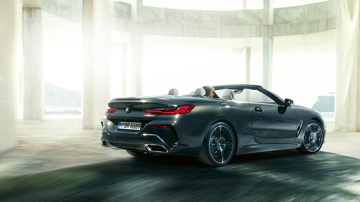 BMW M850i xDrive i rörelse med nedfälld sufflett, sedd från sidan. BMW M850i xDrive i rörelse med nedfälld sufflett, sedd från sidan.