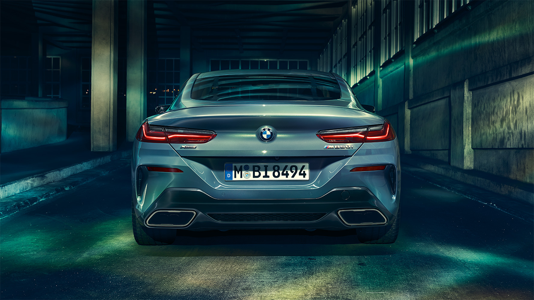 BMW 8-serie Coupé, sedd bakifrån BMW 8-serie Coupé sedd bakifrån framför en urban kuliss på natten.