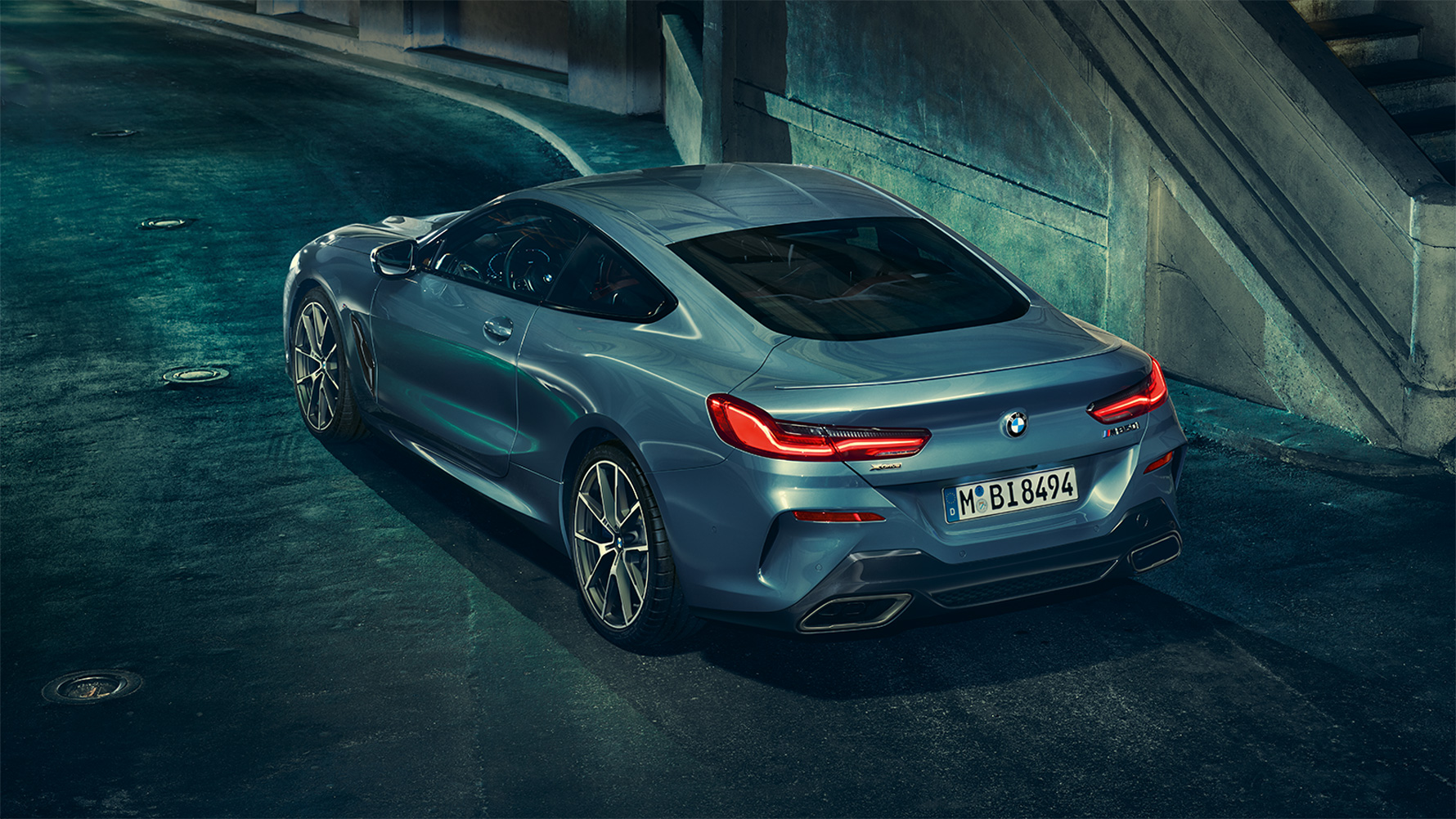 BMW 8-serie Coupé, sedd snett bakifrån BMW 8-serie Coupé sedd snett bakifrån framför en urban kuliss på natten.