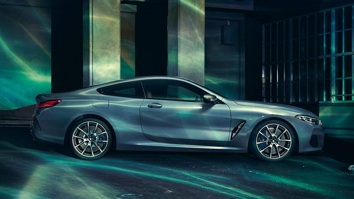 BMW 8-serie Coupé, sedd från sidan. Bild av BMW 8-serie Coupé sedd från sidan framför stadsmiljö.