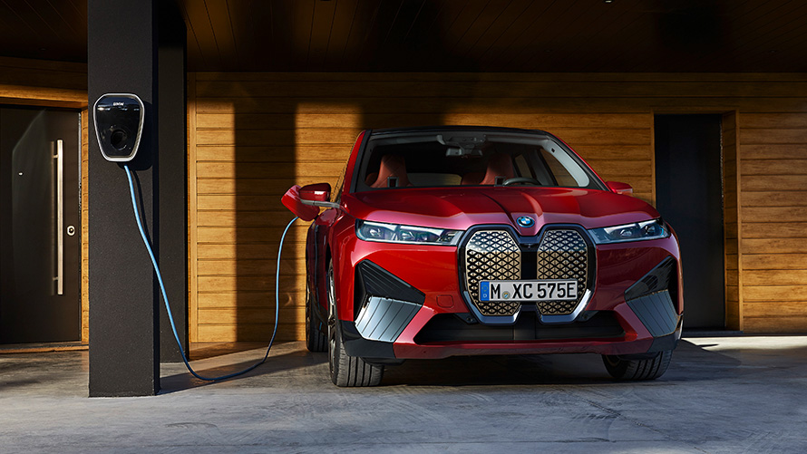 BMW iX i20 eldriven SUV BMW iX xDrive50 laddning BMW iX i20 2021 eldriven SUV BMW iX xDrive50 aventurinröd laddas vid en BMW Wallbox