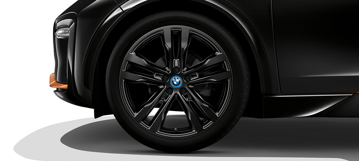 BMW i3s Edition RoadStyle 2019 sedd snett framifrån med fälg BMW i3s Edition RoadStyle 2019 I01 Fluid Black med E-Copper-accenter sedd snett framifrån med fälg
