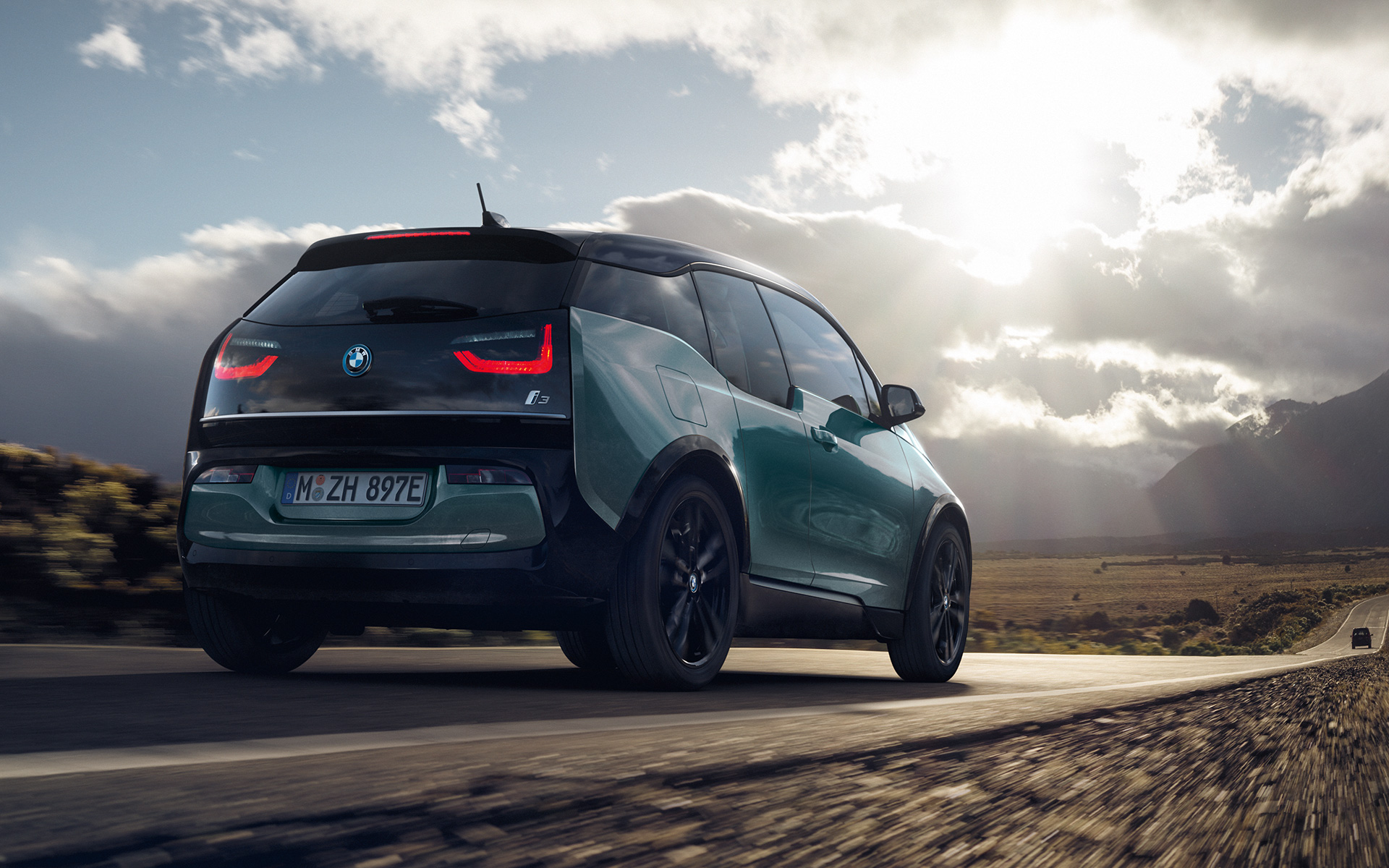 BMW i3 I01 2018 Blue Ridge Mountain med accent Frozen Grey metallic sedd snett bakifrån körande på landsväg