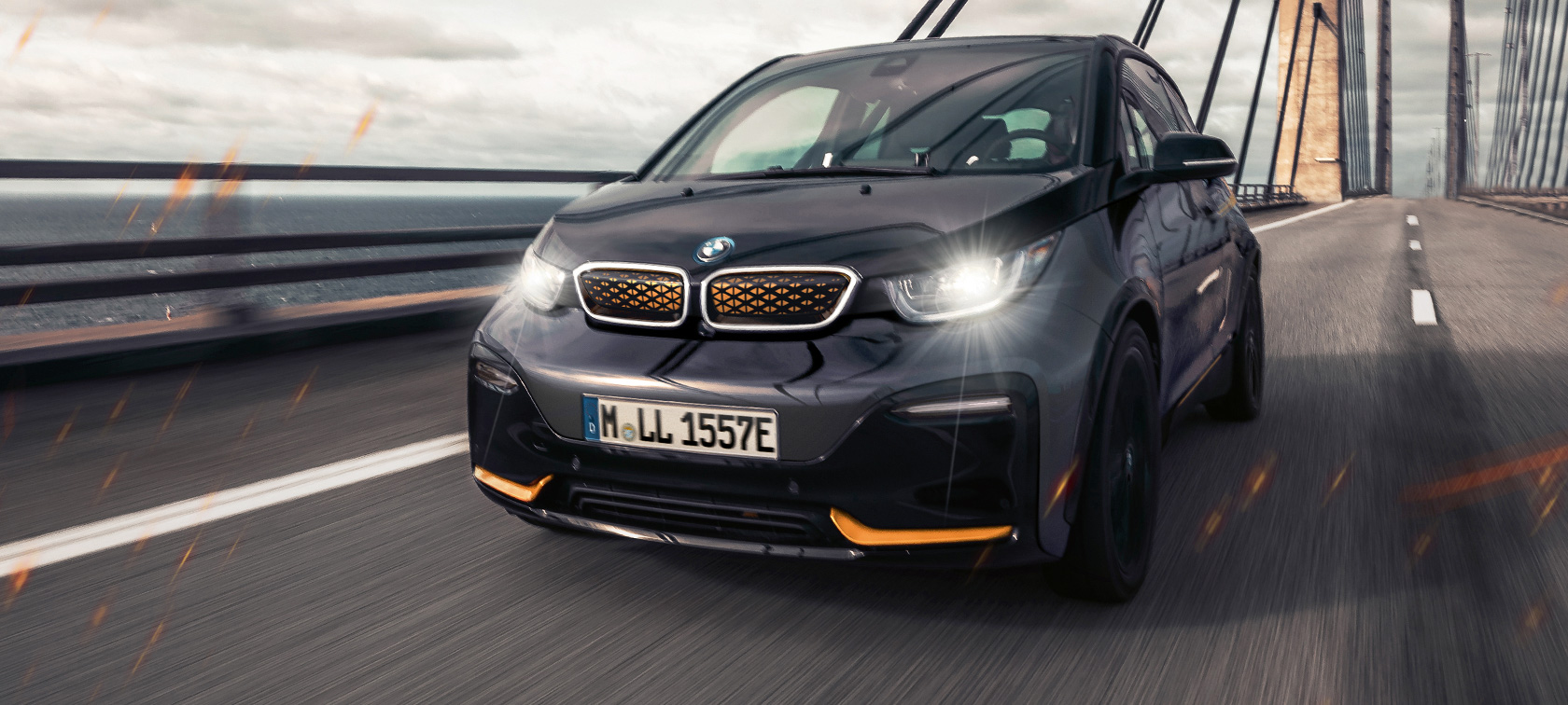 BMW i3 Unique Forever Edition I01 sedd snett framifrån BMW i3 Unique Forever Edition I01 Storm Bay med accent Frozen E-Copper metallic sedd snett framifrån körande på gata