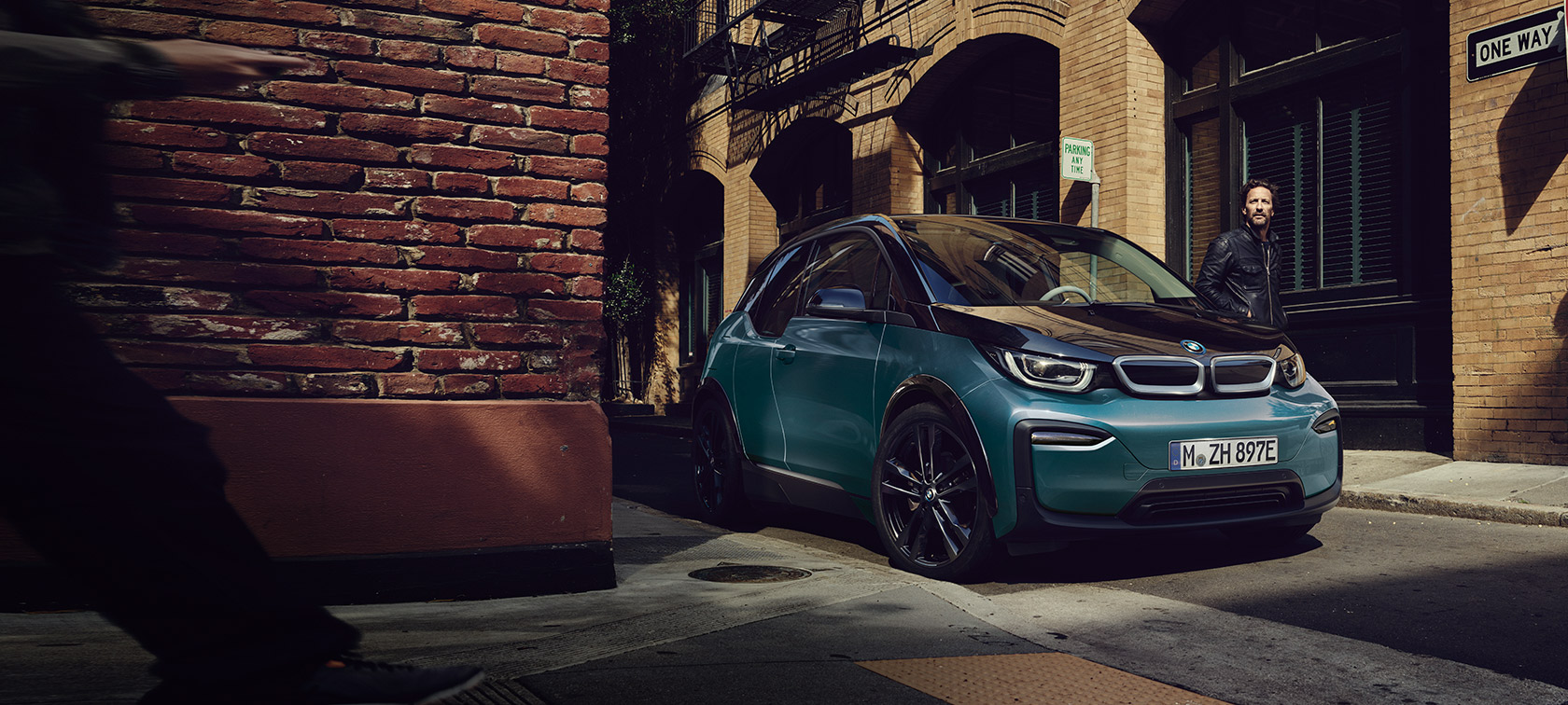 BMW i3 I01 2018 Blue Ridge Mountain med accent Frozen Grey metallic sedd snett framifrån parkerande i stadskuliss