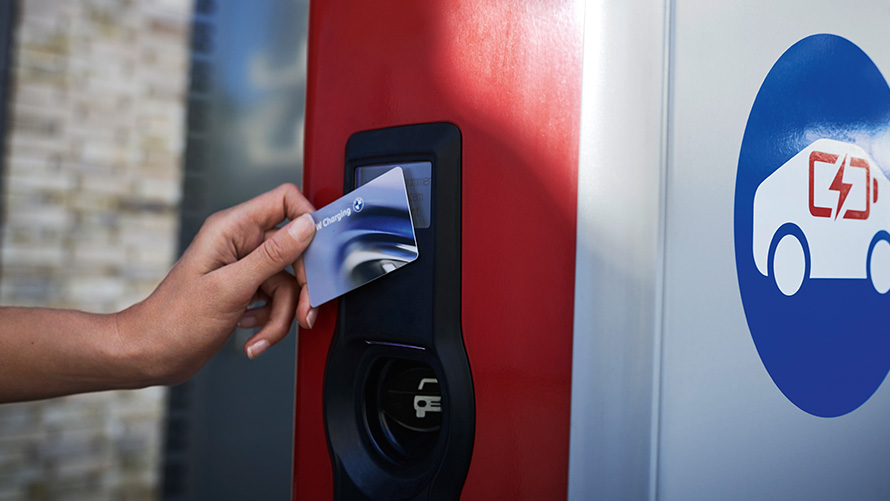 Person med BMW Charging Card vid en publik laddstolpe Person med BMW Charging Card vid en publik laddstolpe