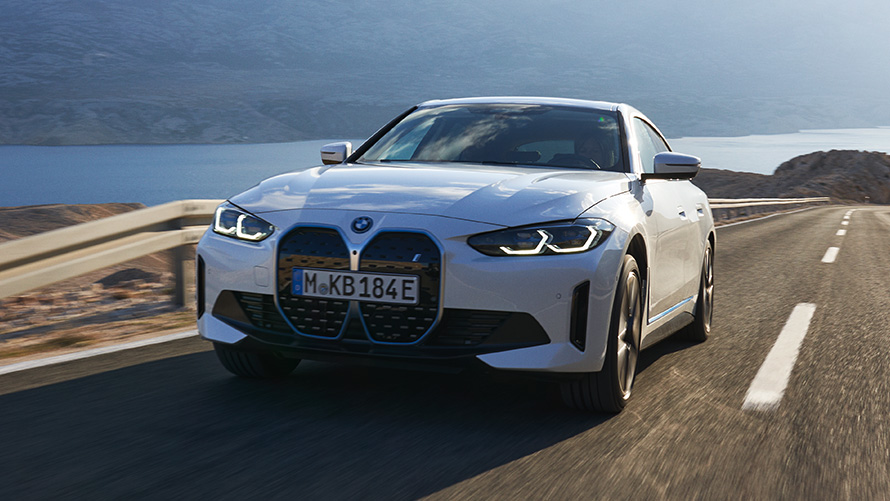 BMW i4 eDrive40 G26 2021 sedd snett framifrån körande BMW i4 eDrive40 G26 2021 Mineralvit sedd snett framifrån körande