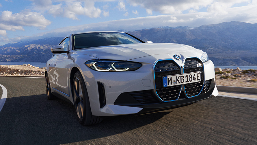 BMW i4 eDrive40 G26 2021 sedd snett framifrån körande BMW i4 eDrive40 G26 2021 Mineralvit sedd snett framifrån körande